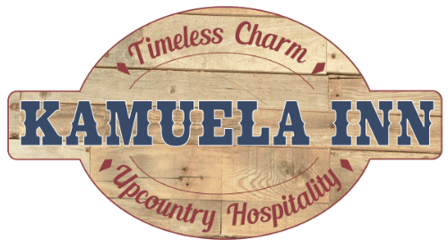 Logo for Kamuela Inn featuring a wooden design with the text "Timeless Charm" and "Upcountry Hospitality."